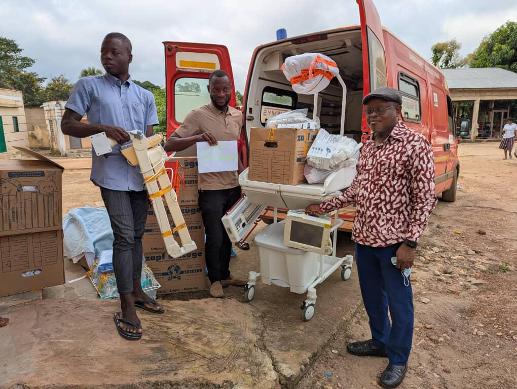 Drei Togolesen beim Packen eines Transporters mit gelieferten Hilfsgütern.